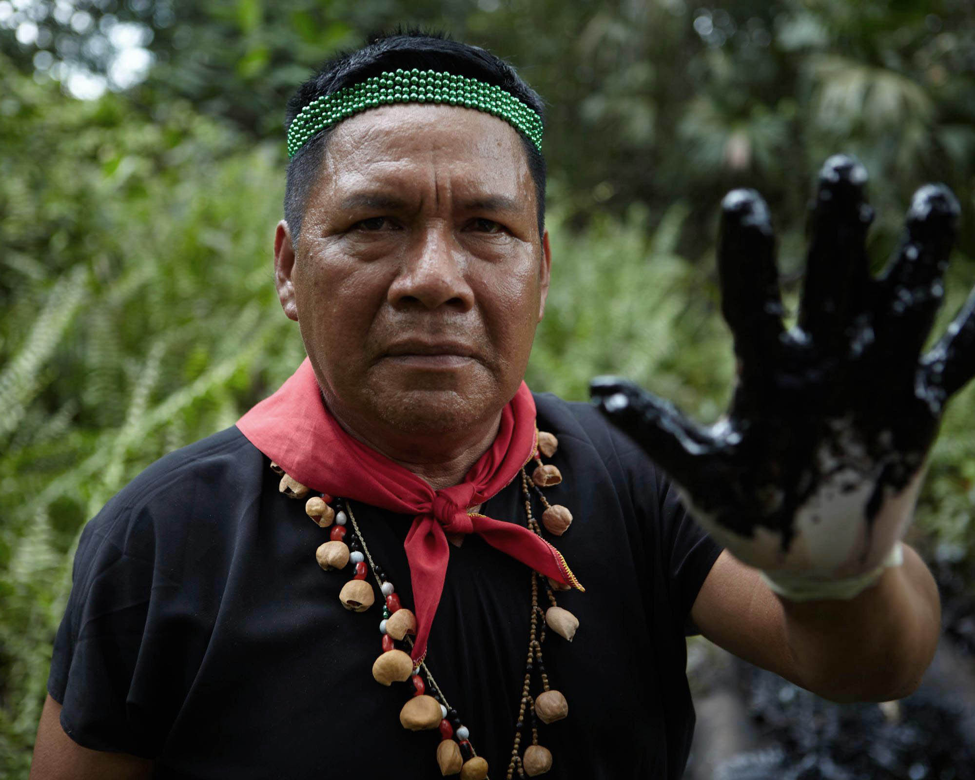 Emergildo Criollo shows how much oil can still be found in the soil of the Amazon region in Ecuador today. Photo by Mitch Anderson